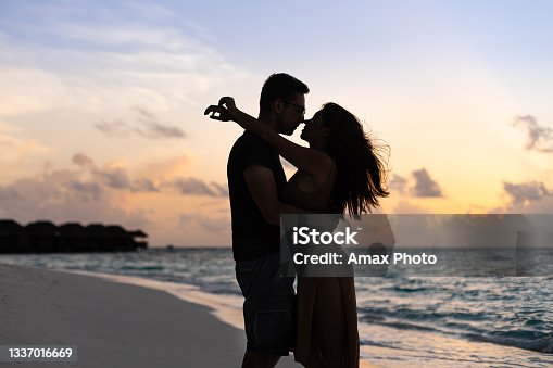 istock Young couple silhouette hugging on the background of sunset in  Maldives near the Indian ocean 1337016669