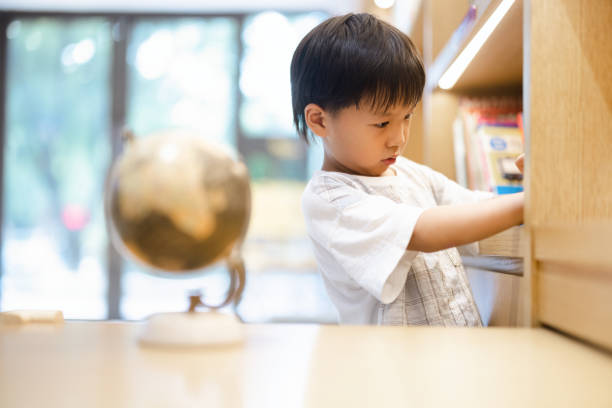 istock A little boy reading in the library 1337022424