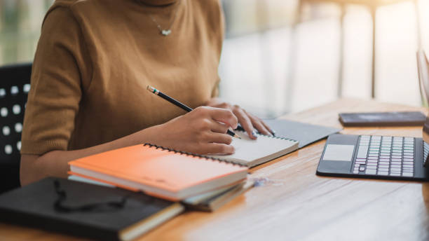 Woman college student who taking notes online learning at home.