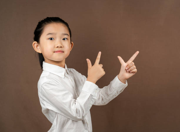 istock Little Girl Showing on Brown Background 1337031972