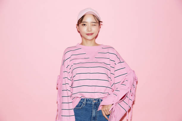 portrait of casual young asian woman with cap on pink background - fashion model pink beauty fashion imagens e fotografias de stock