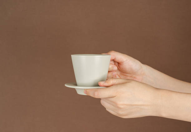 istock Holding Coffee Cup on Brown Background 1337038934