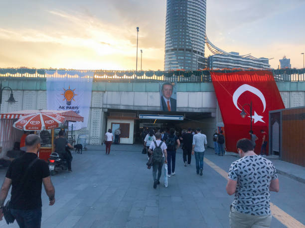poster of President Erdogan with AKP logo and Turkish flag on bridge wall Kadikoy, Istanbul, Turkey - June 04, 2018: people walking and passing through Justice and Development Party and current president Recep Tayyip Erdogan in the evening campaign headquarters stock pictures, royalty-free photos & images