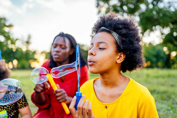 istock Girl blowing bubbles outdoors 1337045007