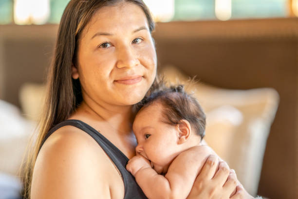 美しい先住民の母親は彼女の赤ちゃんの娘を揺りかご - native american baby love mother ストックフォトと画像