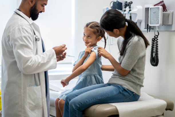 little girl at a doctor's office for a vaccine injection - examination table imagens e fotografias de stock