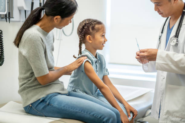 istock Elementary age girl getting a flu shot at a doctor's office 1337046909