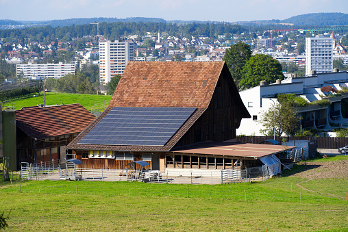 Farm house with solar panels on the roof at City of Zurich on a sunny summer evening. Photo taken August 12th, 2021, Zurich, Switzerland.