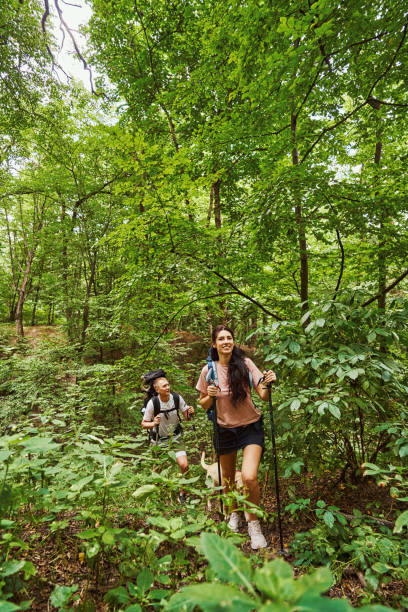 istock Happy young couple enjoying climbing in forest 1337058739