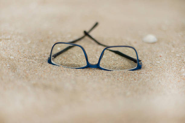istock Blue rimmed glasses on the sand. 1337058960