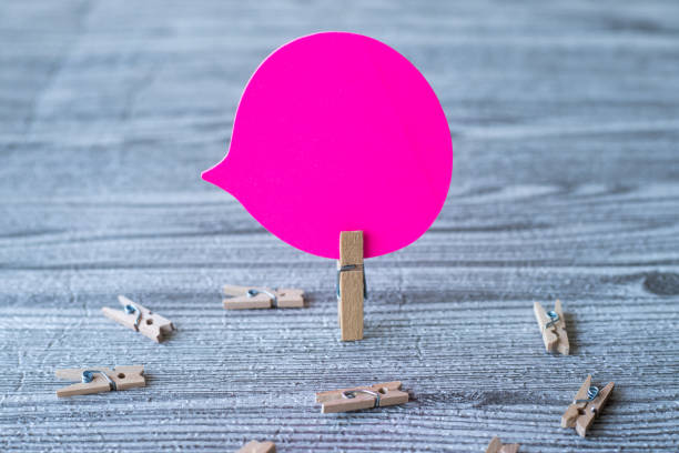 istock Piece Of Blank Speech Bubble Surrounded By Laundry Clips Showing New Meaning. Empty Conversation Balloon Clipped Upright Placed On Top Of Wooden Table Displaying Fresh Idea. 1337061168