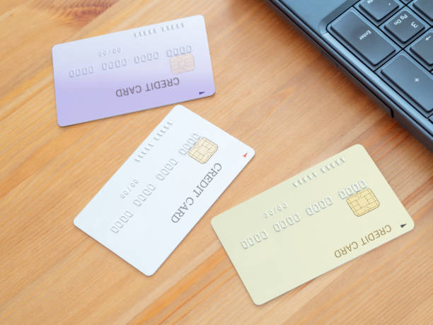 cartões de crédito e laptop - order gear three objects working - fotografias e filmes do acervo