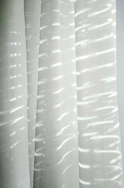 istock Sunlight shines through blinds and a sheer curtain. 1337066812