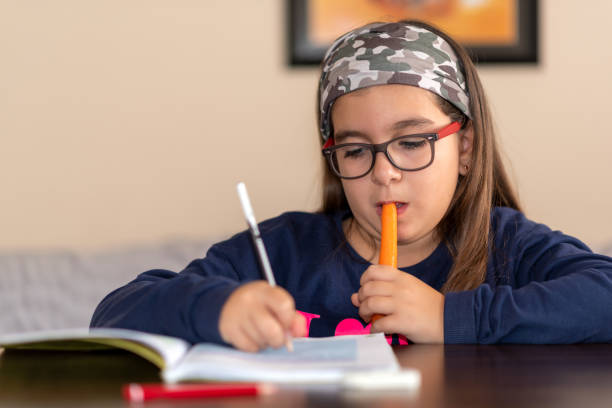 istock little girl studies while eating carrots 1337066989