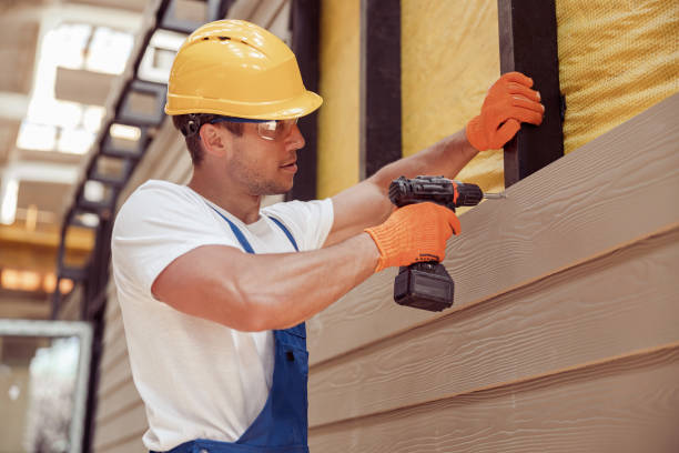 Male builder using power drill at construction site Handsome young man construction worker wearing safety helmet and work gloves while installing exterior wood siding siding contractor stock pictures, royalty-free photos & images