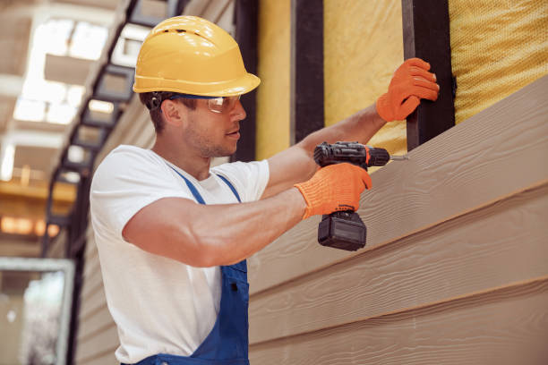 Male builder using power drill at construction site Handsome young man construction worker wearing safety helmet and work gloves while installing exterior wood siding siding stock pictures, royalty-free photos & images