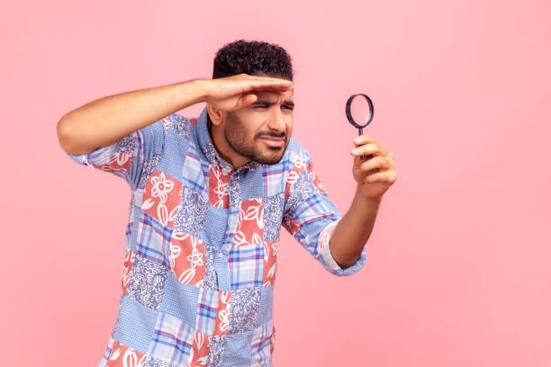 istock Curious bearded man looking away through magnifying glass, keeping palm near forehead, finding out something, exploring, inspecting. 1337069682