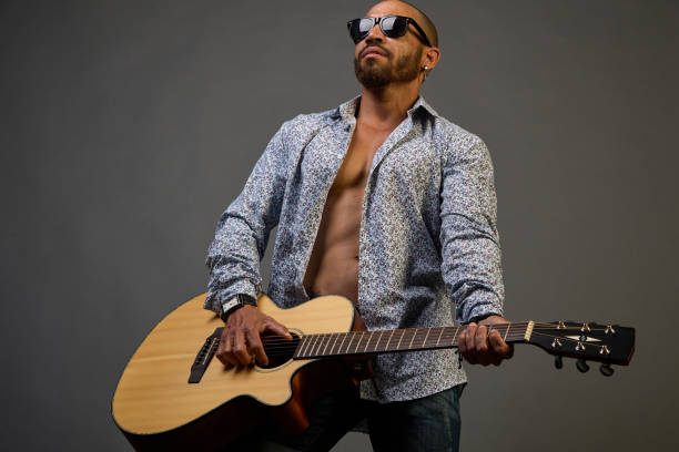 istock Cool guy in sunglasses plays the guitar on a gray background 1337071338