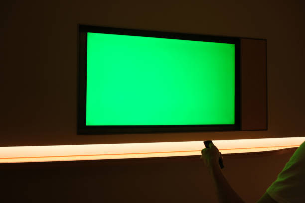istock people watching large green screen TV on wall at dark night 1337072692