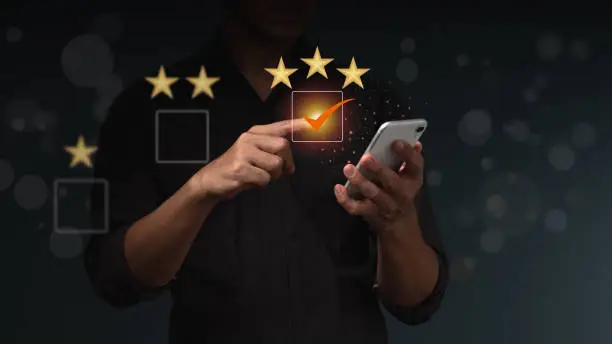 Photo of The businessman uses finger point to check box 3 stars icon for customer services best excellent business rating experience. Satisfaction survey concept.