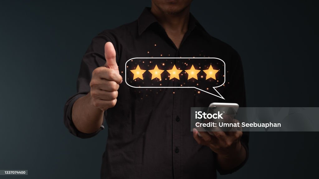 The concept is customer satisfaction. The businessman's hand with thumb up Positive emotion, five stars in balloon massage. Awe Stock Photo