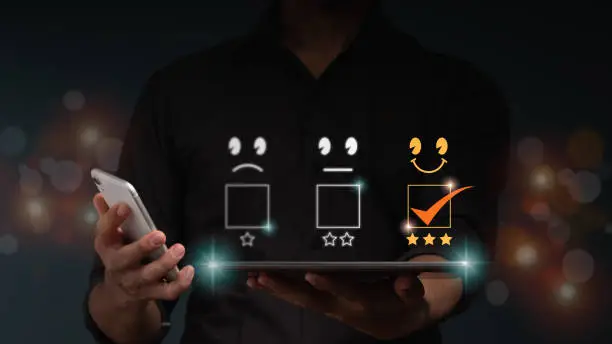 Photo of The businessman holds a tablet computer with a smile and 3 stars icon for customer service best excellent business rating experience. Satisfaction survey concept.
