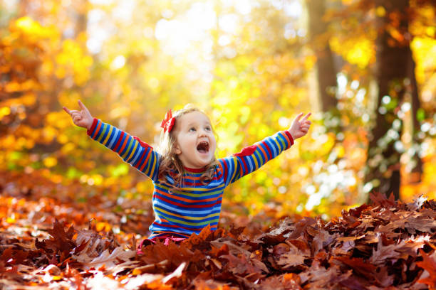 istock Child in fall park. Kid with autumn leaves. 1337075983