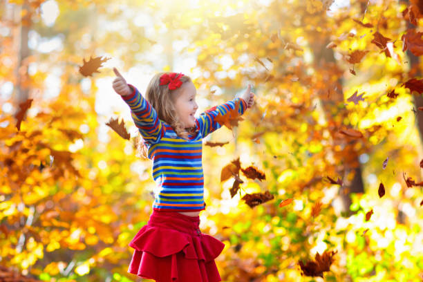 istock Child in fall park. Kid with autumn leaves. 1337076065