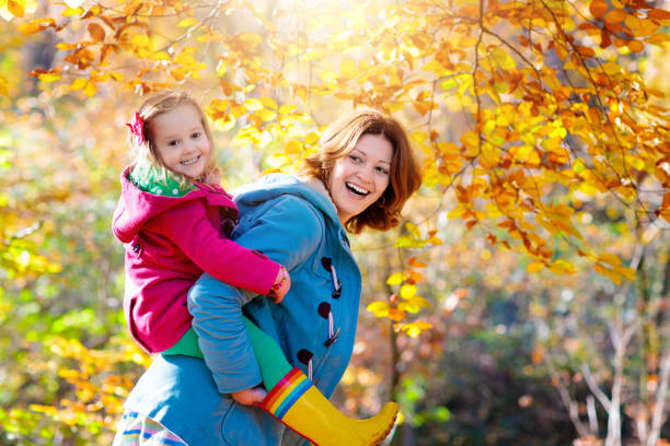 Mother and kid in autumn. Fall outdoor family fun. stock photo