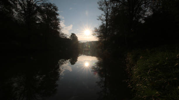 istock Reflection of the setting sun through the trees in the lake 1337077907