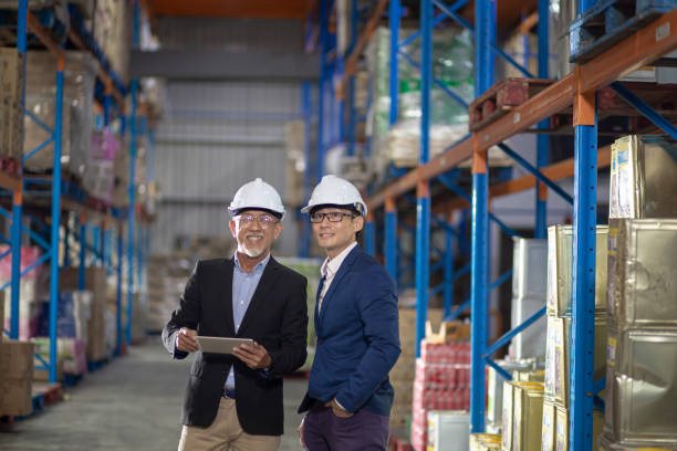 istock Asian Chinese management having discussion at warehouse with white hardhat using digital tablet 1337078074