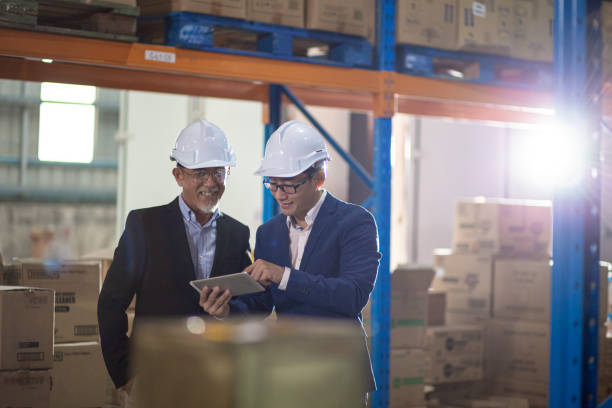 istock Asian Chinese management having discussion at warehouse with white hardhat using digital tablet 1337078076