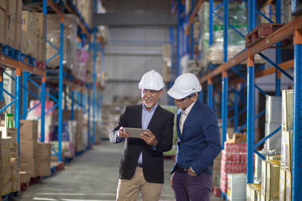 istock Asian Chinese management having discussion at warehouse with white hardhat using digital tablet 1337078090