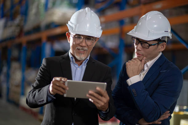 istock Asian Chinese management having discussion at warehouse with white hardhat using digital tablet 1337078127