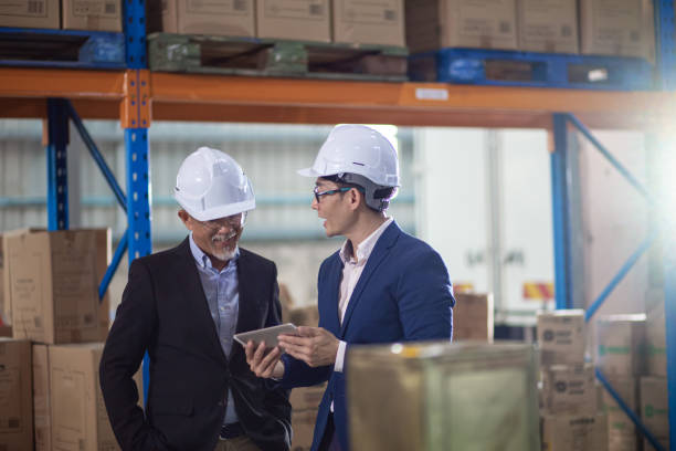 istock Asian Chinese management having discussion at warehouse with white hardhat using digital tablet 1337078189