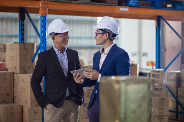 istock Asian Chinese management having discussion at warehouse with white hardhat using digital tablet 1337078191