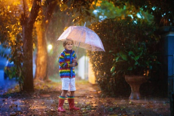 가을 비에서 놀고있는 아이. 우산을 가진 아이. - puddle rain child splashing 뉴스 사진 이미지