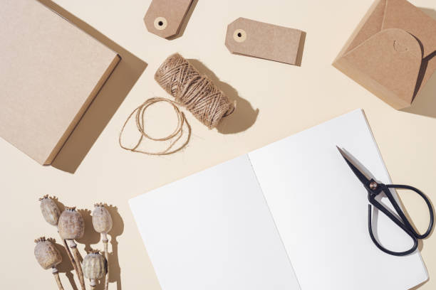istock Top view of open notebook with blank pages and packaging gift on table, autumn concept. Creative workspace 1337080183