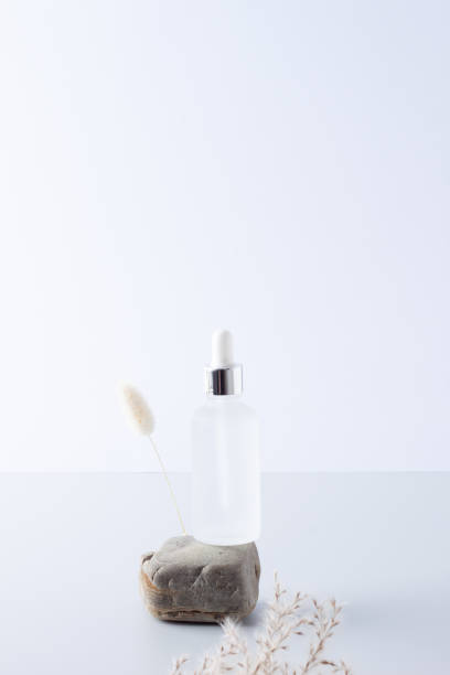 istock Cosmetic bottle with flowers and stone on grey background. Close up, copy space 1337081054