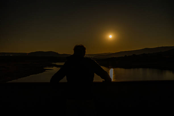 istock looking at the full moon on a bridge 1337081936