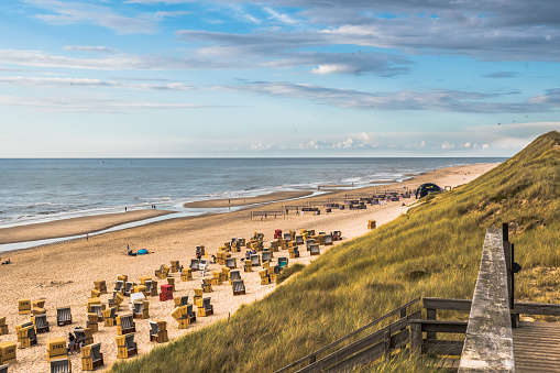Sylt, Germany - August 7, 2021: View from a dune to the beach with beach chairs on the German North Sea island of Sylt