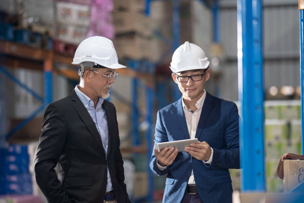 istock Asian Chinese management having discussion at warehouse with white hardhat using digital tablet 1337083840