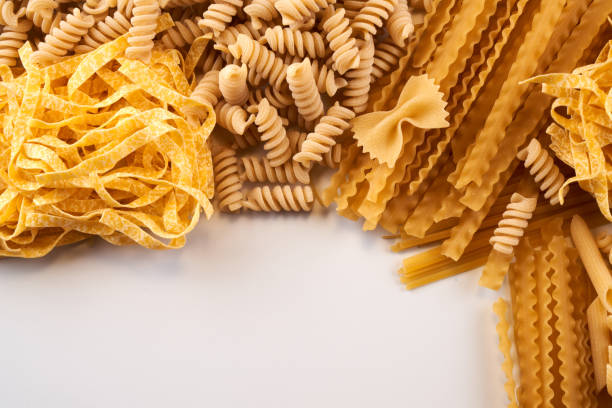 istock Assorted varieties of pasta wallpaper. Mix macaroni, spaghetti on white background with copy space 1337086918