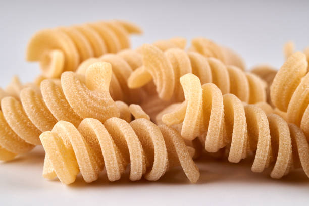 istock spiral noodles close up on white background, pasta and macaroni 1337088525