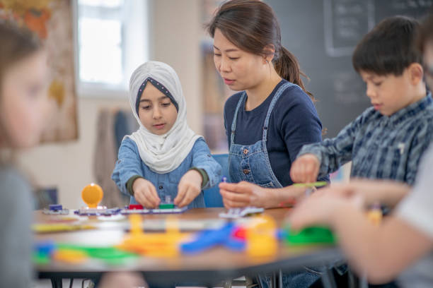 istock Teacher helping a Muslim immigrant student in an elementary classroom 1337091120