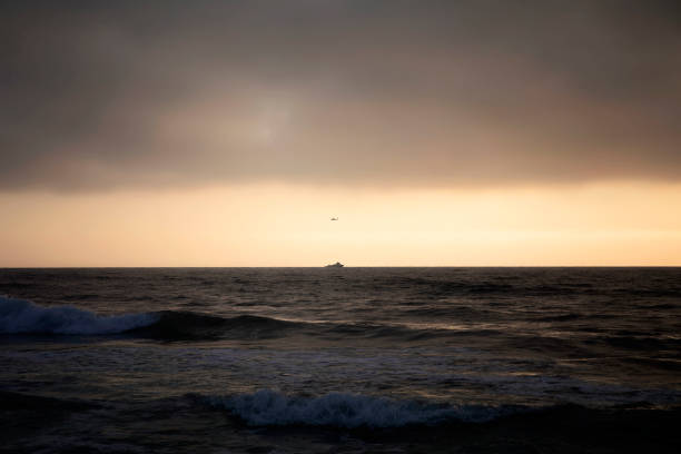 A beautiful and colorful sunset at Windansea Beach in La Jolla with a boat off in the distance
