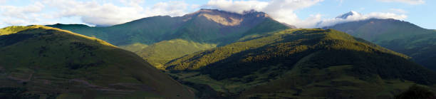 istock Panorama of green mountains with rain clouds 1337092805