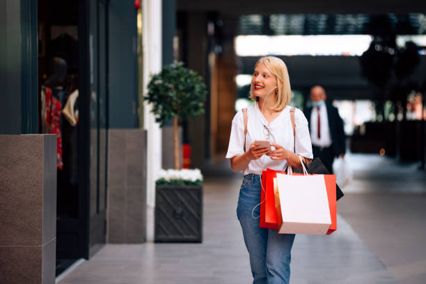 istock Cheerful Woman Using Mobile Phone in Shopping Mall 1337094132