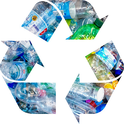 Pile of discarded plastic bottles in recycling symbol - on white background