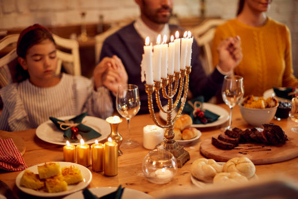 背景に恵みを言ってユダヤ人の家族とメノアの点灯ろうそくのクローズアップ。 - praying saying grace dinner meal ストックフォトと画像